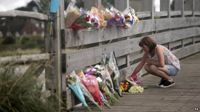 Женщина оставляет цветы в Shoreham