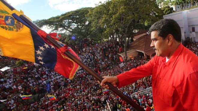 Venezuelan President Nicolas Maduro (C) waving the national flag