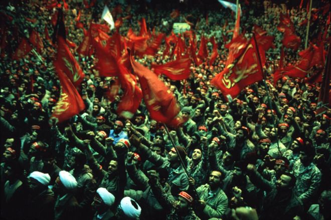Тысячи иранских басиджи (мобилизованных добровольческих сил) держат религиозные знамена и выкрикивают антиамериканские лозунги на митинге перед их отъездом на фронт, стадион Широуди, Тегеран, 4 февраля 1986 года