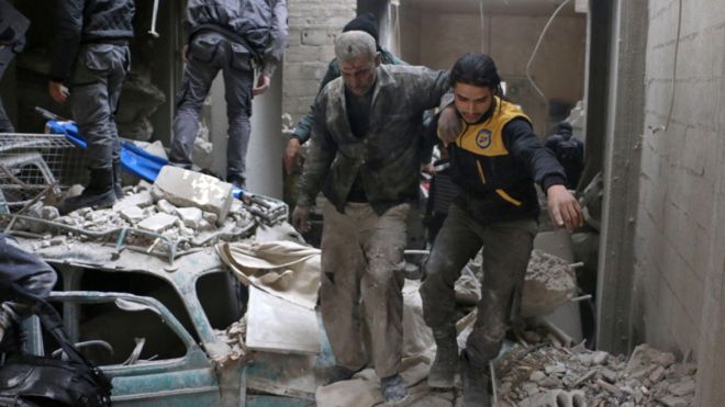 Rescue workers evacuate a wounded civilian from the site of a reported government air strike in Douma, in the besieged rebel-held Eastern Ghouta, Syria (22 February 2018)