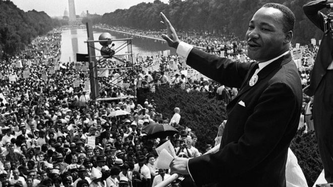 This August 28, 1963 file photo shows US civil rights leader Martin Luther King (C) waving from the steps of the Lincoln Memorial to supporters on the Mall in Washington, DC