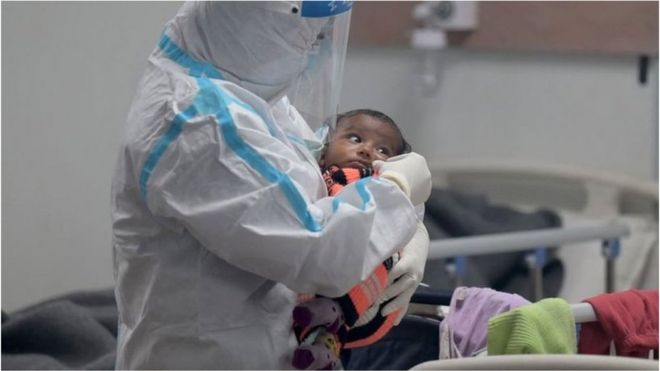 A health worker comforts a child with Covid-19