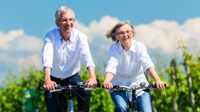 Пожилая пара катается на велосипеде