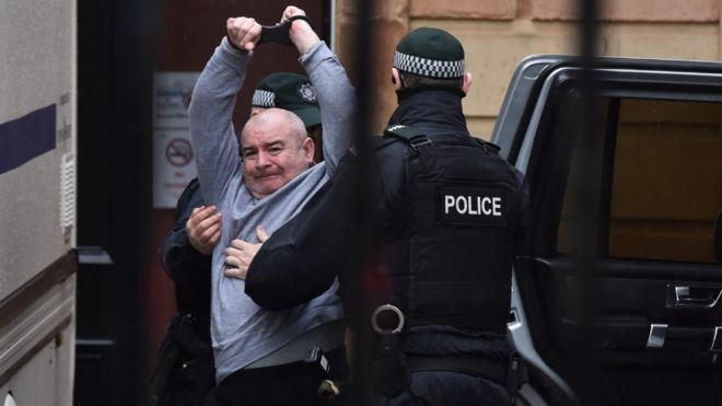 Пол Макинтайр, человек, обвиняемый в убийстве Лайры Макки, поднимает руки, когда он прибывает в Мировой суд Лондондерри 13 февраля 2020 года в Лондондерри, Северная Ирландия
