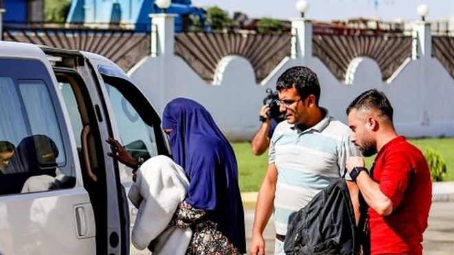 A suspected IS member (centre) carrying her baby is escorted into a vehicle in Syria's north-eastern city of Qamishli, after she was handed over to Sudanese diplomats by Kurdish officials. Photo: 20 September 2018