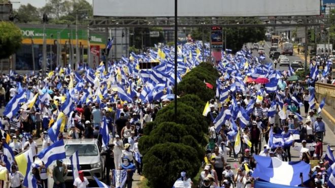 Демонстранты держат национальные флаги во время марша в поддержку католической церкви в Манагуа, Никарагуа 28 июля 2018 года