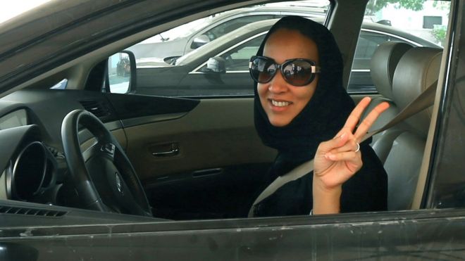 Активист из Саудовской Аравии Манал Аль Шариф показывает 22 октября 2013 года знак победы в своей машине