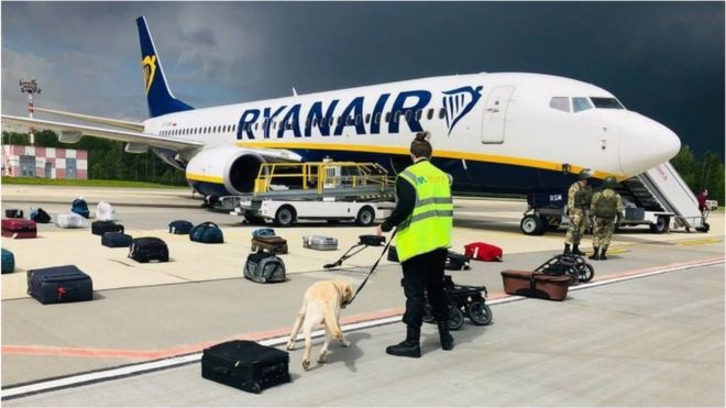 Belarusian security officials with with a sniffer dog checking the luggage of passengers in front of the diverted Ryanair flight at Minsk airport. Photo: 23 May 2021