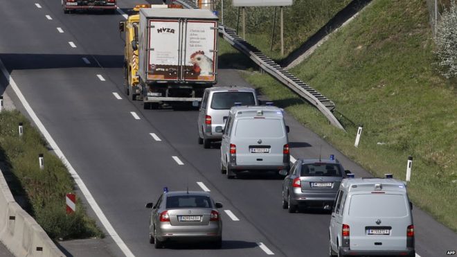 Колонна полицейских автомобилей следует за грузовиком-рефрижератором, буксируемым вдоль шоссе возле Нойзидль-ам-Зее, Австрия (27 августа 2015 г.)