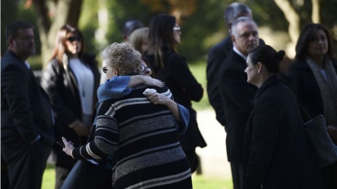 Женщины обнимаются, когда они прибывают за пределы общины Родефа Шалома, где состоятся похороны для расстрелянных жертв Сесила Розенталя и Дэвида Розенталя