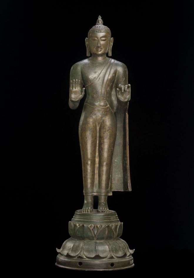 Бронзовая статуя Будды с пламенем на голове, которое символизирует мудрость.