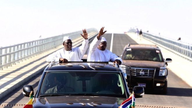 Президент Сенегала Маки Салл (слева) и президент Гамбии Адама Барроу (справа) машут рукой на открытии моста в Фарафенни