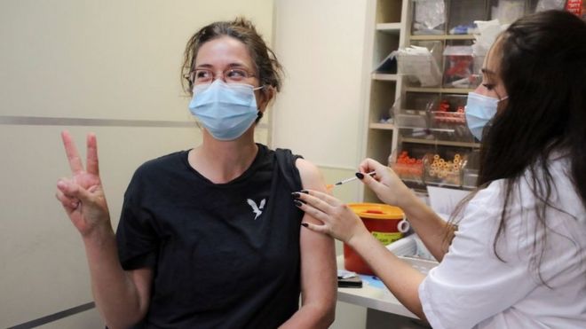 An Israeli woman poses for a picture as she receives a third shot of coronavirus disease (COVID-19) vaccine as country launches booster shots for over 40-year-olds, in Jerusalem August 20, 2021.