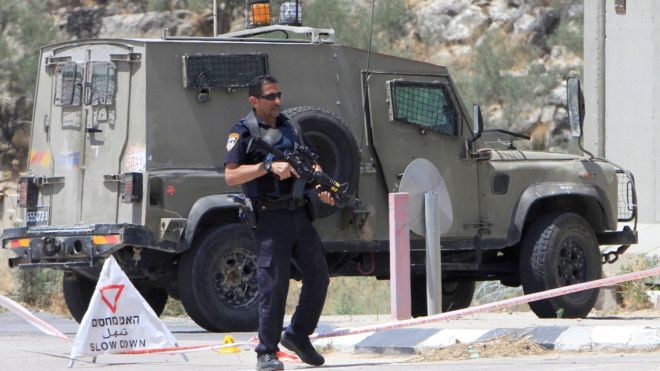 An Israeli policeman stands guard at the scene where a Palestinian woman was shot dead