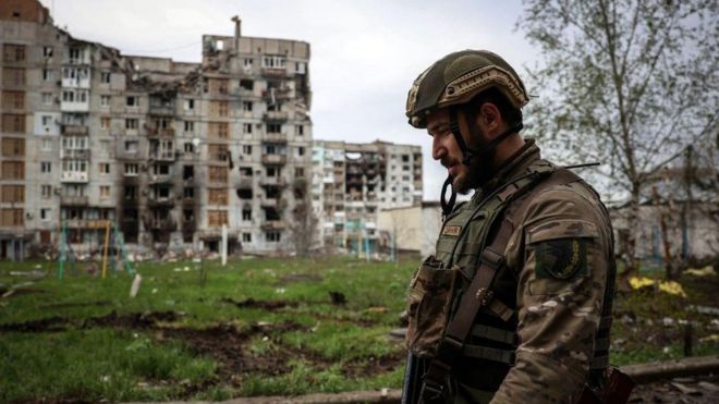 Un soldat ukrainien marche près d'un bâtiment résidentiel endommagé par un bombardement dans la ville de Bakhmut, sur la ligne de front.
