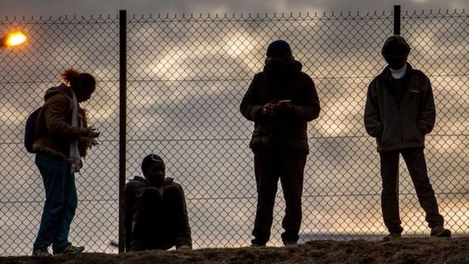 Мигранты выступают против забора звена цепи внутри площадки Евротоннеля в Кокель, недалеко от Кале