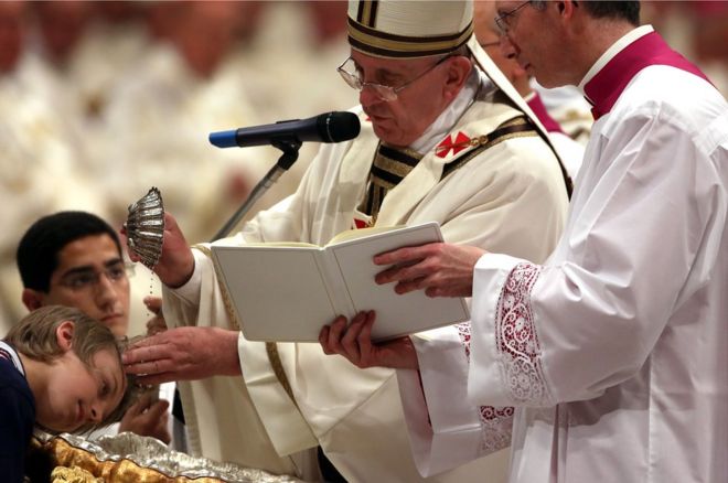 Папа Франциск крестит во время бдения Пасхи в Великую субботу в базилике Святого Петра 19 апреля 2014 года в Ватикане