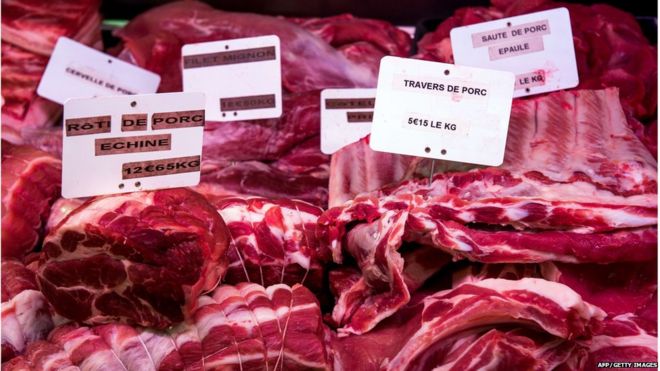 Снимок, сделанный 13 августа 2015 года в Wambrechies, северная Франция, показывает куски мяса свинины, показанные в мясной лавке.
