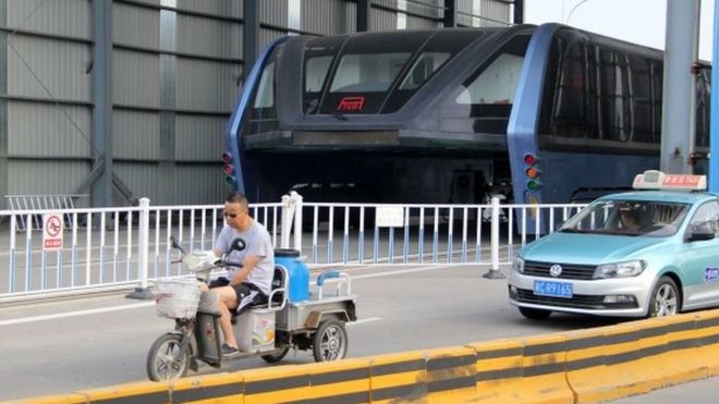 A car drives past the Transit Elevated Bus (TEB) on Fumin road in Qinhuangdao city, north China"s Hebei province, 21 June 2017.