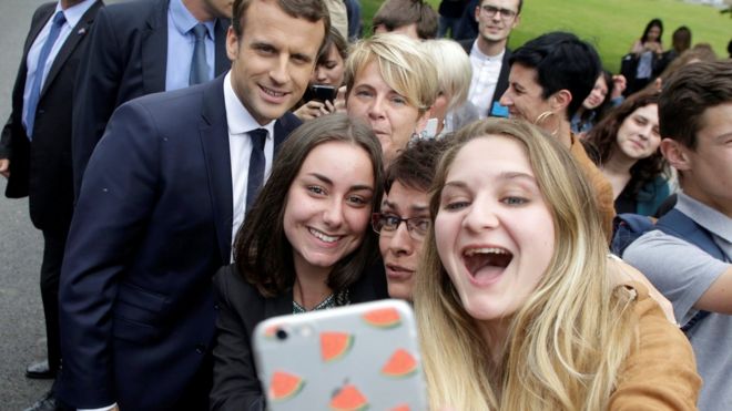 Студенты делают селфи фото с президентом Франции Эммануэлем Макроном (сзади слева) во время его визита в сельскохозяйственный колледж Vaseix в Верней-сюр-Вьенн, Франция, 9 июня 2017 года