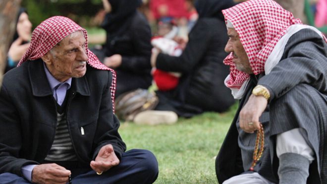 Мужчины сидят и разговаривают в преимущественно сирийском районе Газиантеп