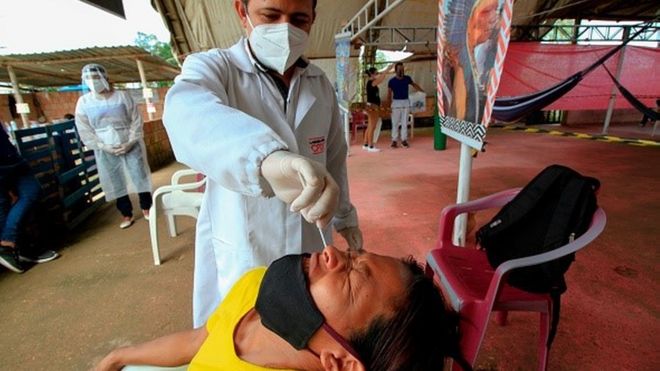 Profissional da saúde coloca swab nasal em homem
