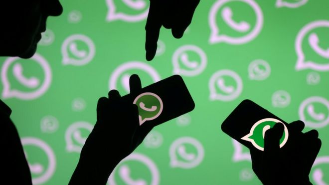 Pessoas com celulares que mostram o logo do WhatsApp