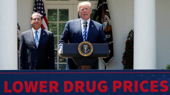 Министр здравоохранения и социального обеспечения Алекс Азар слушает, как президент США Дональд Трамп выступает с речью о снижении цен на лекарства, отпускаемые по рецепту, в Розовом саду в Белом доме в Вашингтоне, США, 11 мая 2018 года.