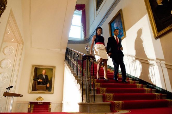 Президент США Барак Обама и первая леди Мишель Обама спускаются из резиденции в Большой фойе Белого дома в Вашингтоне, округ Колумбия, 27 июля 2009 г.