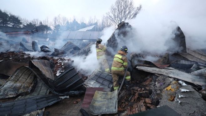 Пожарные пытаются тушить все еще горящий дом, разрушенный сильным лесным пожаром в Сокчо, Южная Корея, 5 апреля 2019 года
