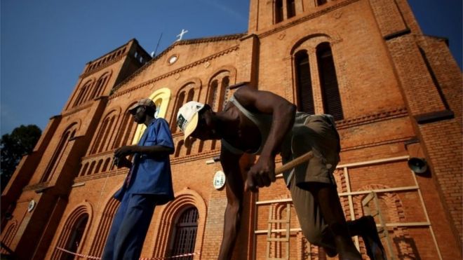 Мужчины работают перед собором Непорочного Зачатия Нотр-Дам, где Папа Франциск посетит, в Банги, Центральноафриканская Республика, 26 ноября 2015 года.