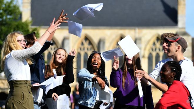 Сомто Элумого (в центре) и другие ученики празднуют свои результаты GCSE в школе Норвич в Норвич, Норфолк
