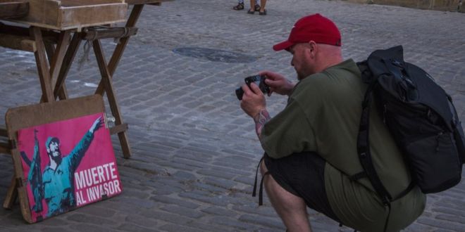 Турист фотографирует картину в Гаване