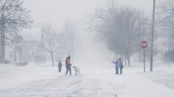FLINT, MICHIGAN-DECEMBER 23-A family walks and runs during a winter snow storm affecting most of the USA, in Flint, MI on December 23, 2022.