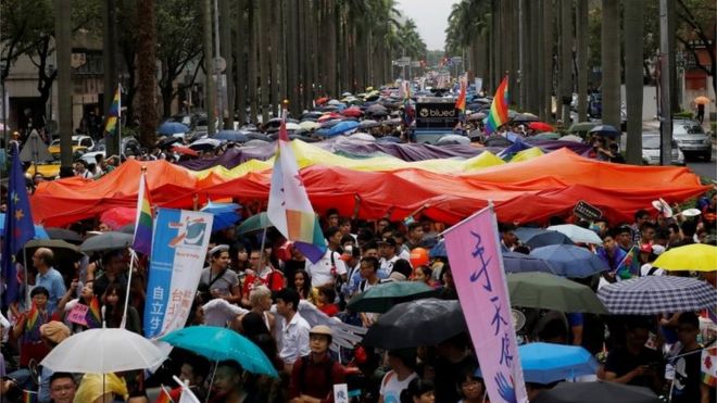 Участники держат гигантский радужный флаг, принимая участие в гей-параде лесбиянок, геев, бисексуалов и трансгендеров (ЛГБТ) в Тайбэе, Тайвань, 29 октября 2016 года.