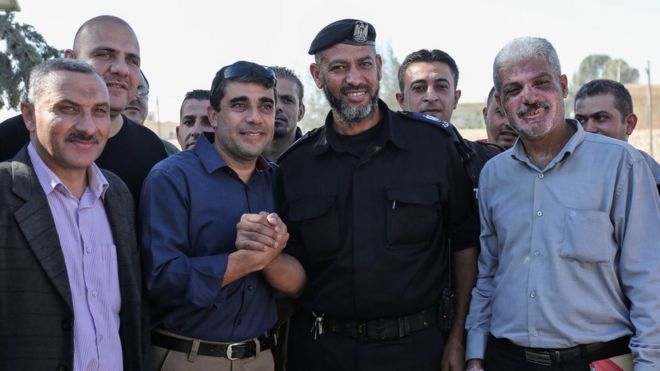 Член Палестинской автономии (C-L) обменивается рукопожатиями с сотрудниками сил безопасности ХАМАС на пограничном пункте Рафах с Египтом (1 ноября 2017 года)