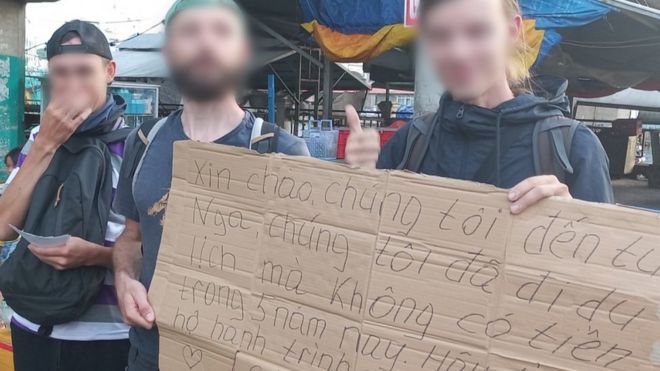 Hình ảnh ba thanh niên Nga cầm bảng xin tiền đi du lịch ở chợ Dương Đông – Phú Quốc