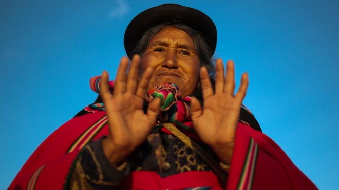 Una mujer aymara levanta sus manos durante la celebración de Willkakuti (Regreso al Sol) 5530 en Tiahuanaco, Bolivia el 21 de junio de 2022.
