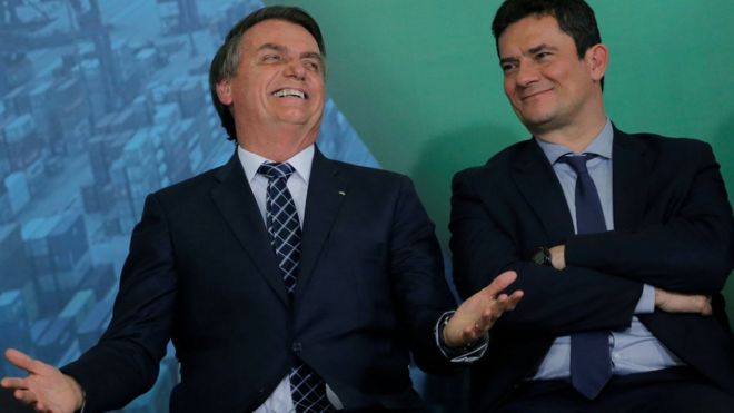 Bolsonaro dá risada ao lado de Moro sorrindo em foto de 2019