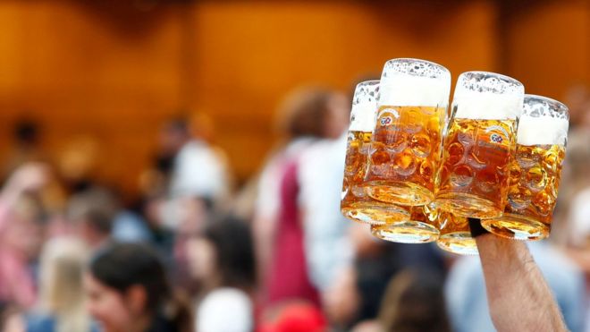 Официант несет бокалы с пивом в день открытия Октоберфеста в Мюнхене