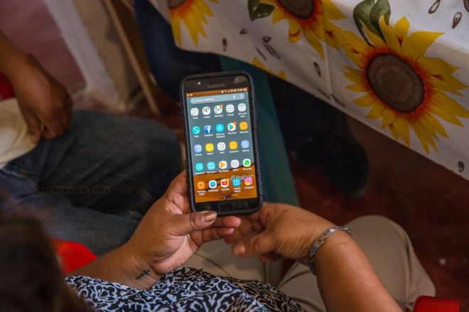 Мария дель Росарио Родригес держит сотовый телефон своего сына Рикардо Флореса в доме их семьи в Акатлен, Пуэбла, Мексика, 18 октября 2018 года