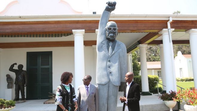 Грэйс Мугабе (слева) с Робертом Мугабе, статуей и Домиником Бенхурой, справа