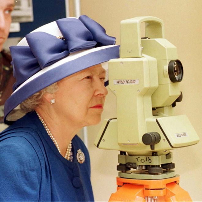 Королева Елизавета II смотрит через теодолит