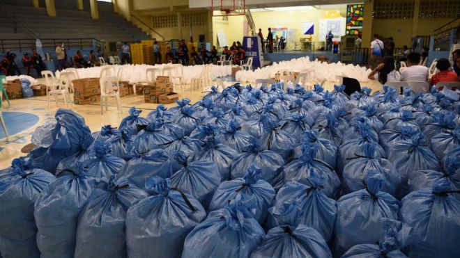 Мешки, содержащие пакеты с продовольственной помощью, будут разосланы жителям, пострадавшим от тайфуна, 14 сентября 2018 года