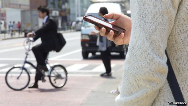 Человек с помощью мобильного телефона на улице в Токио, Япония