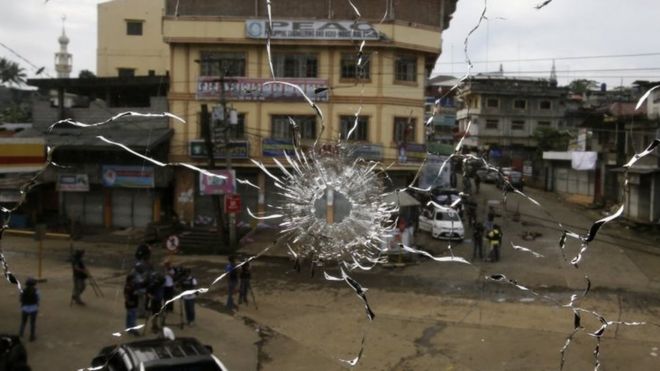 Вид улицы через поврежденное оконное стекло от снайперской пули во время боя между правительственными солдатами и повстанцами в городе Марави, Минданао. Фото: 29 мая 2017 г.