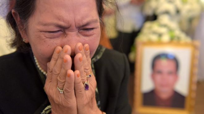 Камбоджийская женщина плачет возле портрета Кема Лея (R), политического аналитика и борца за демократию, во время похоронной церемонии в Пномпене 12 июля 2016 года