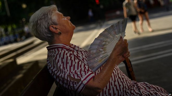 Женщина использует вентилятор для охлаждения в Памплоне, на севере Испании, 30 июня 2015 года