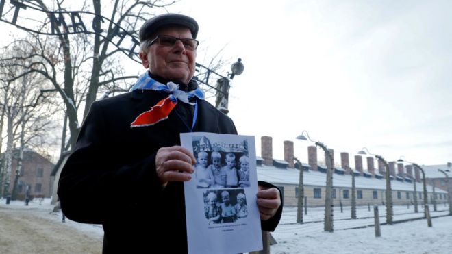 Оставшийся в живых держит плакат в бывшем немецко-фашистском концентрационном лагере Освенцим, где он присутствует на церемониях, посвященных 74-й годовщине освобождения лагеря и Международному дню памяти жертв Холокоста, в Освенциме, Польша