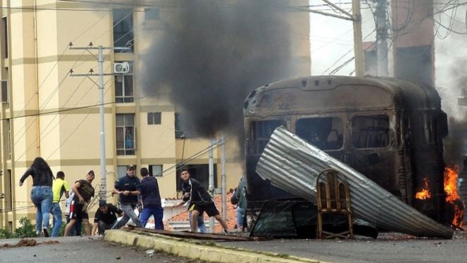 Столкновения демонстрантов с силами безопасности ОМОНа: поджог автобуса во время акции протеста против правительства президента Венесуэлы Николаса Мауро в Сан-Кристобале, Венесуэла, 29 мая 2017 года.